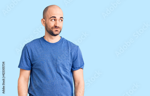 Young handsome man wearing casual t shirt smiling looking to the side and staring away thinking.