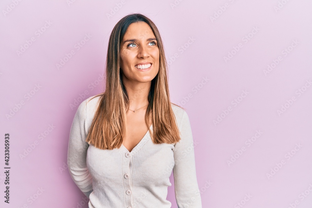 Brunette young woman wearing casual clothes looking to side, relax profile pose with natural face and confident smile. Brunette young woman wearing casual clothes looking to side, relax profile pose with natural face and confident smile.