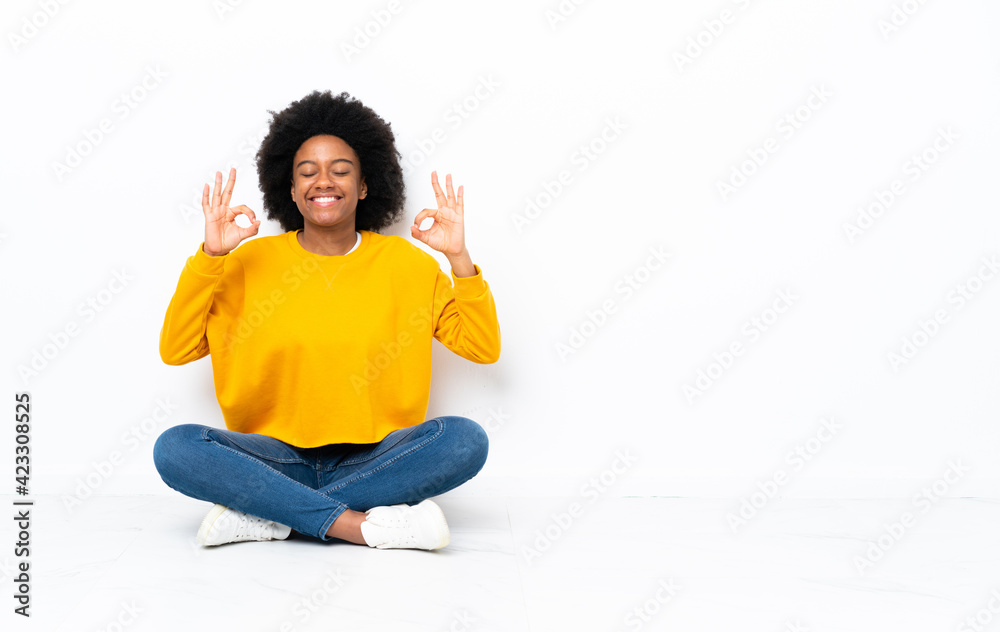 Young African American woman sitting on the floor in zen pose