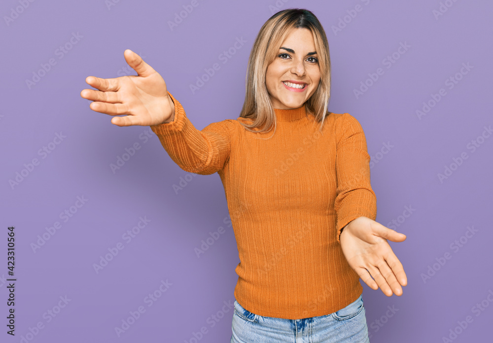 Young caucasian woman wearing casual clothes looking at the camera smiling with open arms for hug. cheerful expression embracing happiness. Young caucasian woman wearing casual clothes looking at the camera smiling with open arms for hug. cheerful expression embracing happiness.