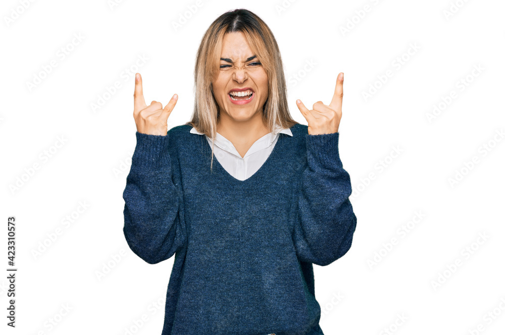 Young caucasian woman wearing casual clothes shouting with crazy expression doing rock symbol with hands up. music star. heavy music concept. Young caucasian woman wearing casual clothes shouting with crazy expression doing rock symbol with hands up. music star. heavy music concept.