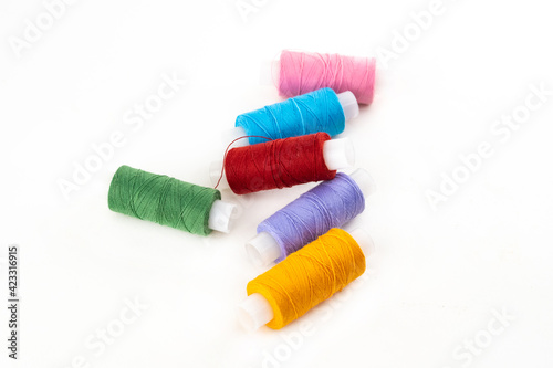 set of multi-colored cotton threads skeins scattered on an isolated white background