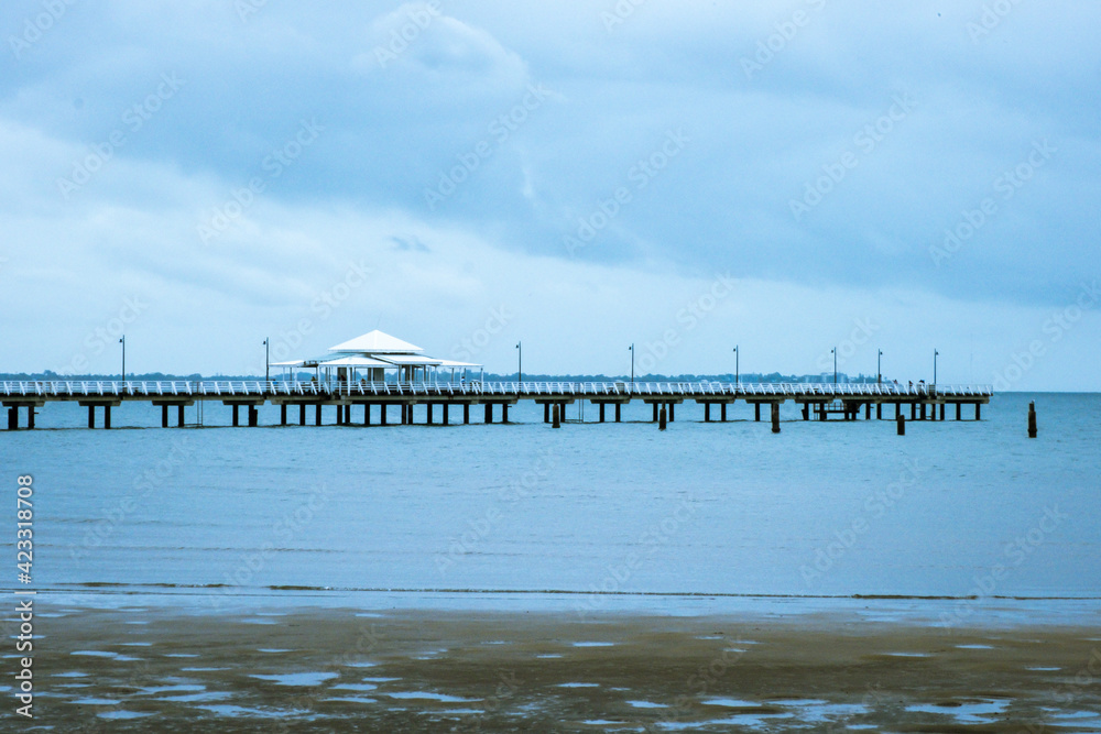 Shorncliffe Pier with cloudy sky. The jetty is scene from the beach.