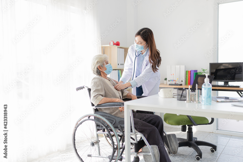 Asian doctor talk with old female patient about disease symptom, doctor use stethoscope listening lung of patient, elderly health check up , they wear surgical mask, corona virus 