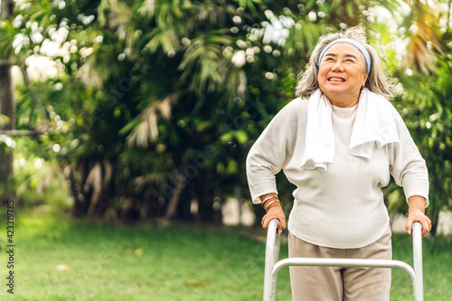 Portrait of happy senior adult elderly asian woman smiling and feeling breathe fresh air and exercise on sunny morning in the park.Retirement and healthcare concept