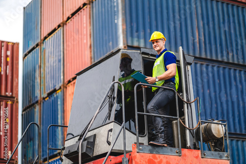 Professional engineer container cargo foreman in helmets working standing and using walkie talkie checking stock into container for loading.logistic and business export