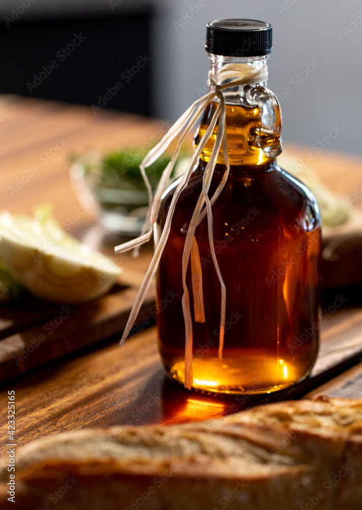 Bouteille en verre avec du sirop d'érable déposé sur une planche en bois