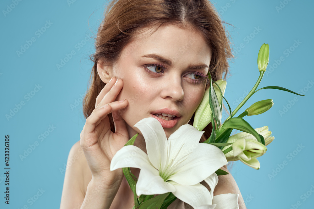 Girl with a bouquet of white flowers on a blue background red hair portrait model Girl with a bouquet of white flowers on a blue background red hair portrait model