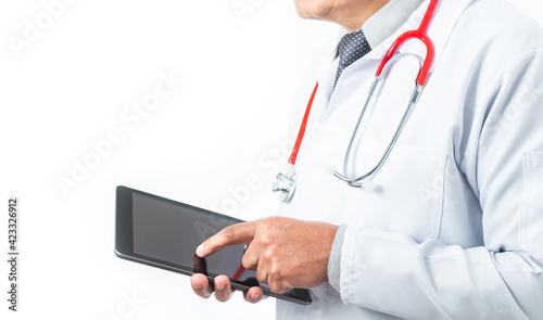 Medium shot of a doctor in a gown and tie whose face is not recognizable with a stethoscope and a tablet. Medicine and technology concept