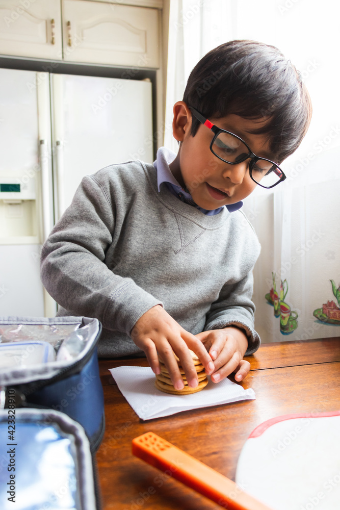 A small child wrapping cookies with a napkin A small child wrapping cookies with a napkin