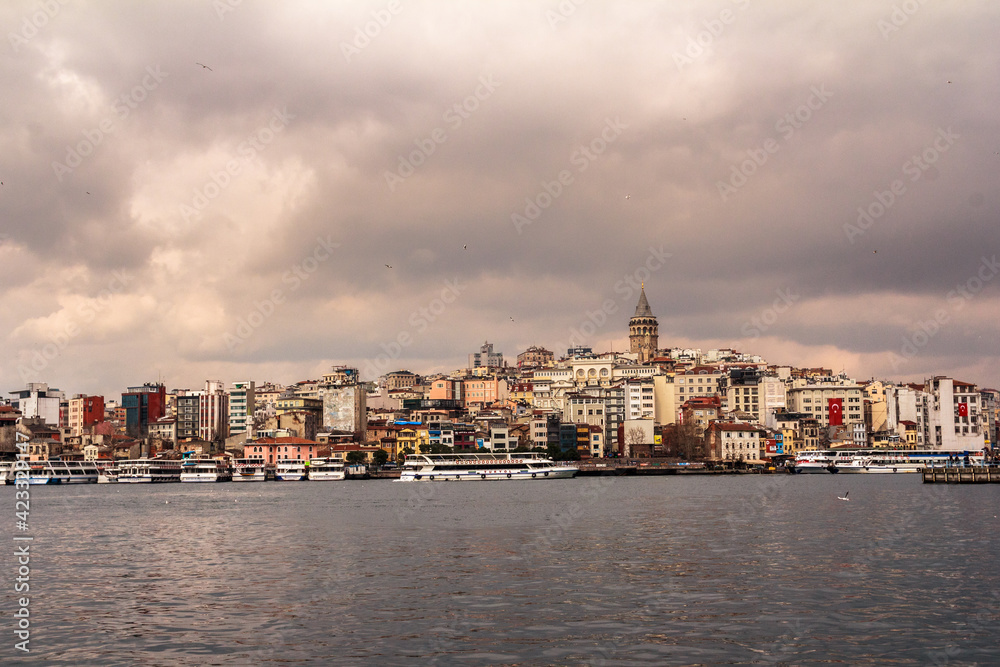 View of  Galata Tower and Galata District in Istanbul from  Galata Bridge on a cloudy day. Copy space, stock photo