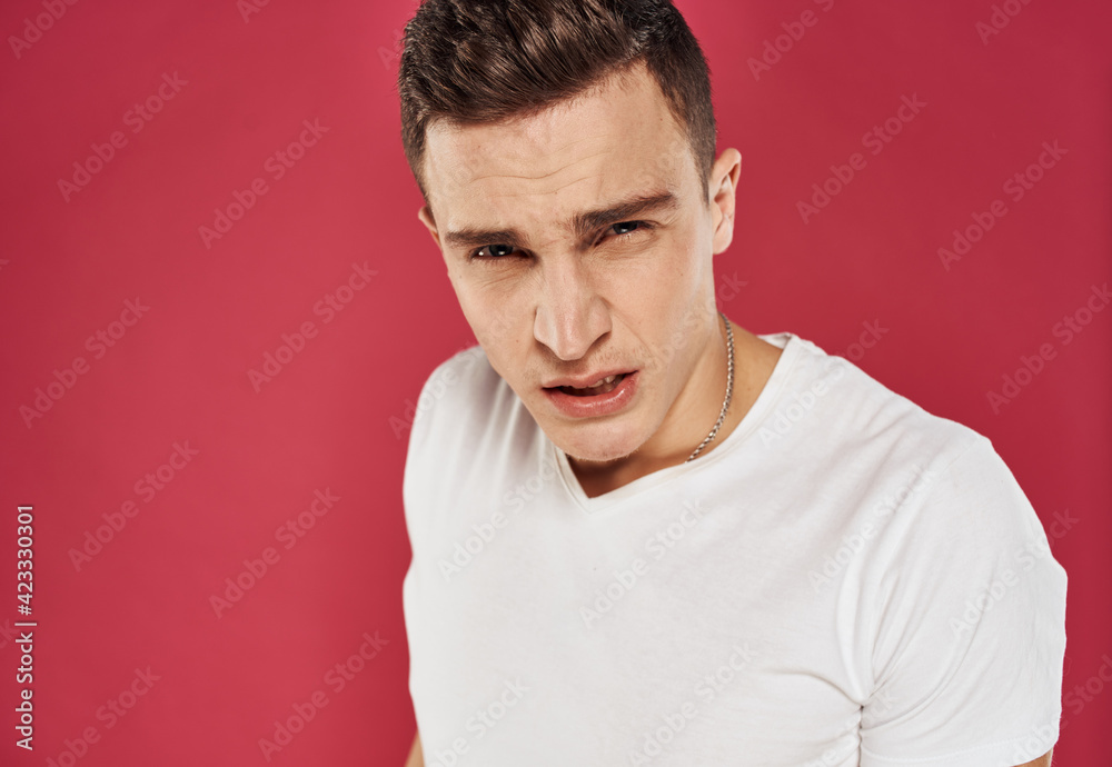 man in white t-shirt close-up red background dissatisfaction man in white t-shirt close-up red background dissatisfaction