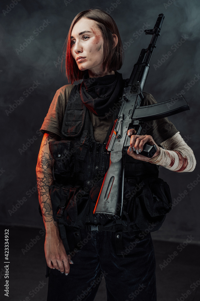 Beautiful female soldier with rifle on her shoulder in smokey background Beautiful female soldier with rifle on her shoulder in smokey background