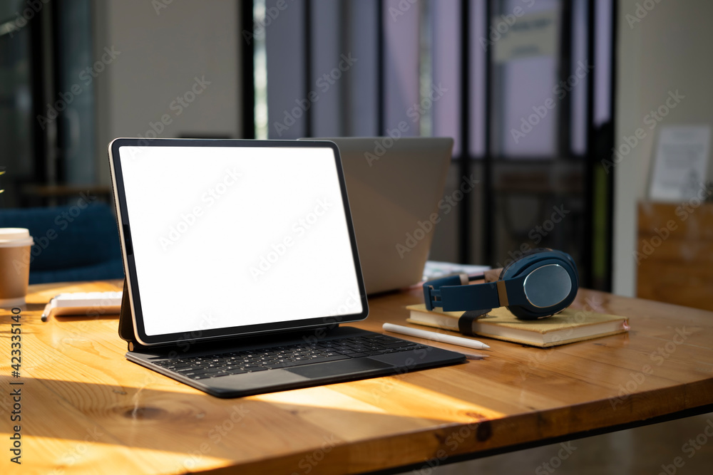 Mock up computer tablet with white screen, head phone and notebook on wooden desk. Mock up computer tablet with white screen, head phone and notebook on wooden desk.