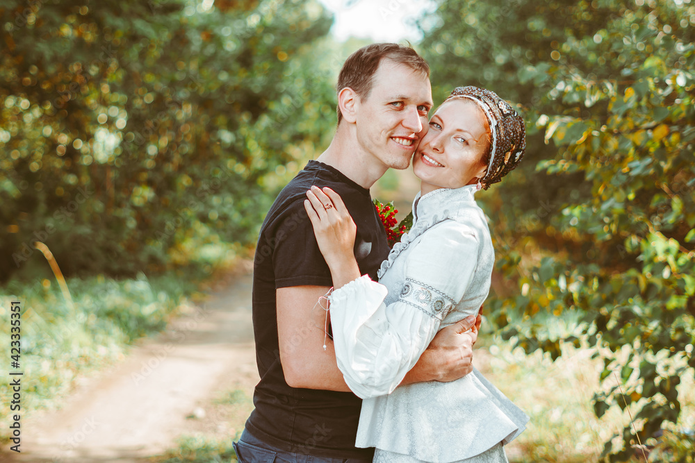 a guy and a girl are standing in an embrace on a field of grass a guy and a girl are standing in an embrace on a field of grass