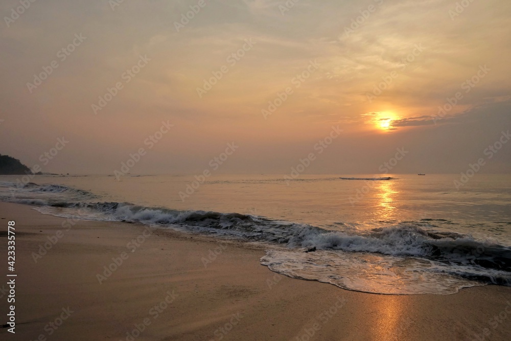 In selective focus silhouette sunrise with golden light on water surface and clean waves