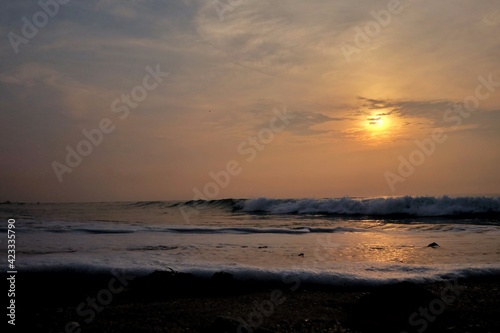 In selective focus silhouette sunrise with golden light on water surface and clean waves