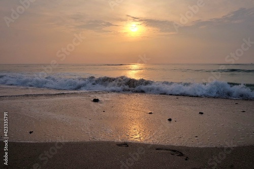 In selective focus silhouette sunrise with golden light on water surface and clean waves