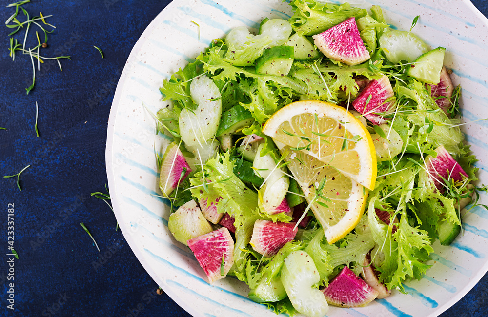 Salad from watermelon radish, cucumber, celery and lettuce leaves. Vegan food. Dietary menu. Top view, overhead, copy space Salad from watermelon radish, cucumber, celery and lettuce leaves. Vegan food. Dietary menu. Top view, overhead, copy space