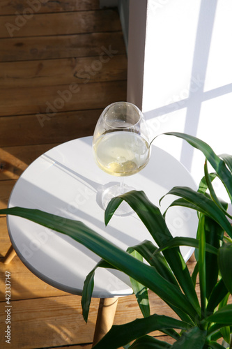 One glass of white wine is on the side table