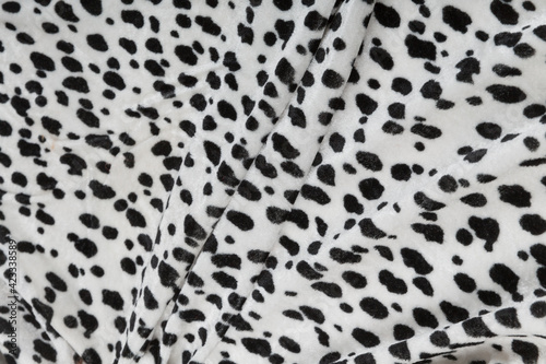 Colored black textile satin fabric folded in folds and waves with highlights and texture