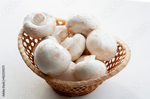 Fresh mushrooms in a basket isolated on a white background