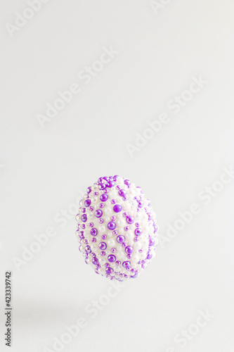 The creative Easter concept made of natural eggs with purple stickers levitates on a gray background. Minimal holiday or spring concept.