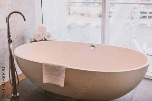 Luxury bathroom with white bath  picture window and fresh towels. Interior design in hotels. 