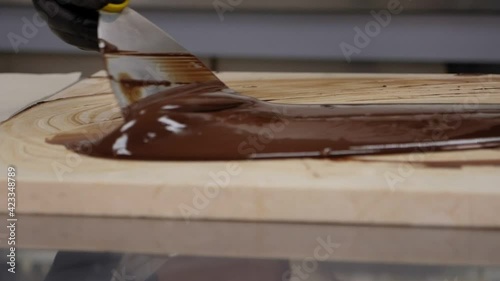 Tempering of the chocolate on the wooden surface. photo