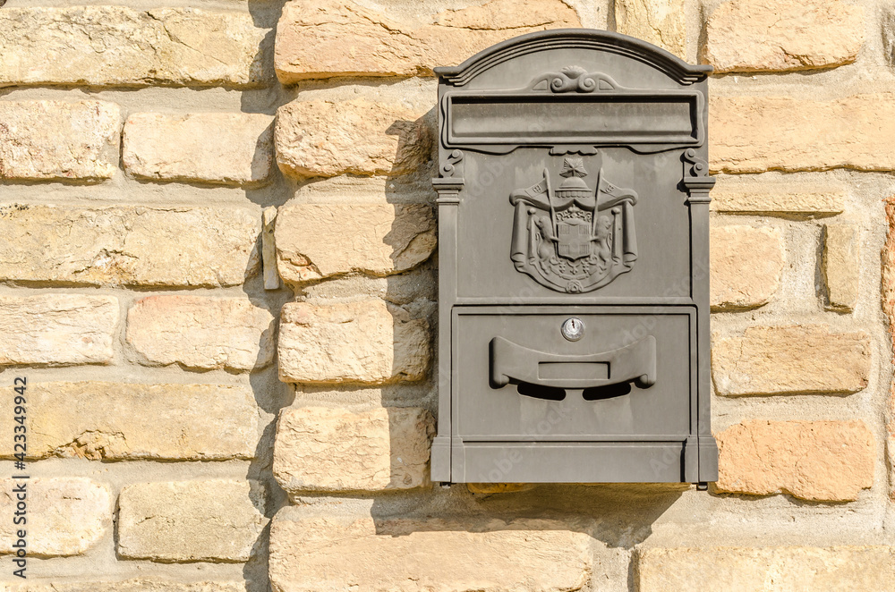 Hanging ornamental mailbox on the facade of the house