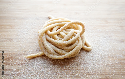 Fresh Pici Pasta nest on a wooden board