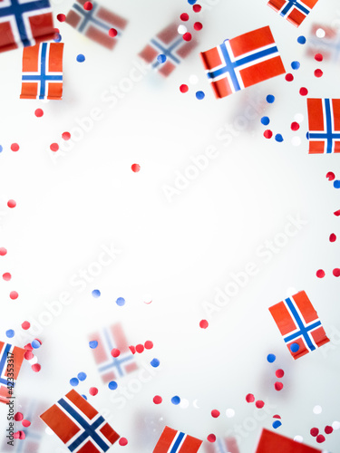 Norwegian independence day, Constitution day, may 17. holiday of freedom, victory and memory. concept of patriotism and faith. paper confetti and mini flags on white foggy background