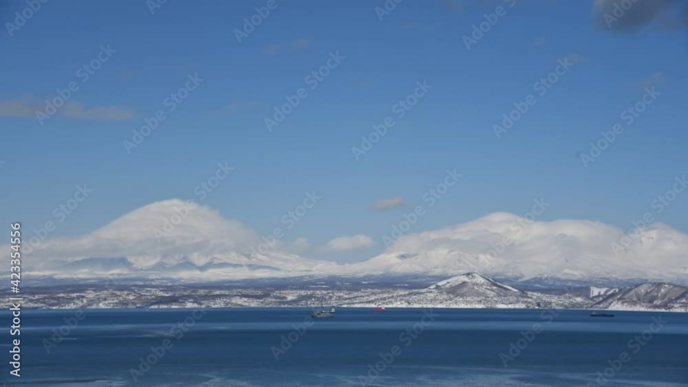 video with snow-capped volcanoes in Kamchatka, calmly sailing ships across the Pacific Ocean and rapidly rushing clouds video with snow-capped volcanoes in Kamchatka, calmly sailing ships across the Pacific Ocean and rapidly rushing clouds