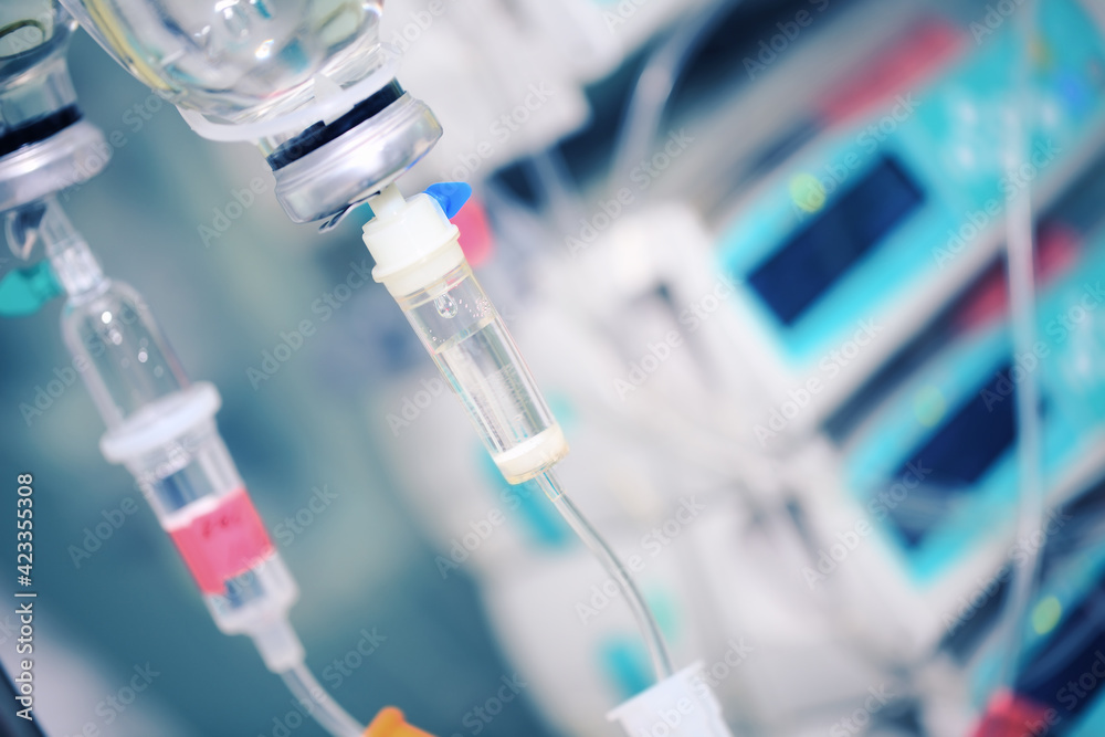 Intravenous drip bottles on the background of hospital equipment