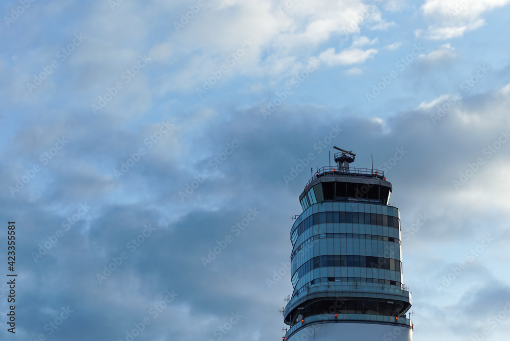 Airport control tower against blue cloudy sky