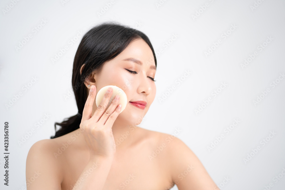 Skin care and healthy treatment of woman removing makeup from face with cotton pad. Isolated on white background. Skin care and healthy treatment of woman removing makeup from face with cotton pad. Isolated on white background.