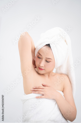 Woman touches flawless soft skin under her arms isolated on white background.