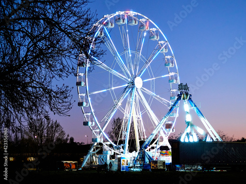 Ferris wheel and amusement park at dusk, at night.