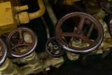 row of iron valves on a submarine old and shabby to adjust the water system