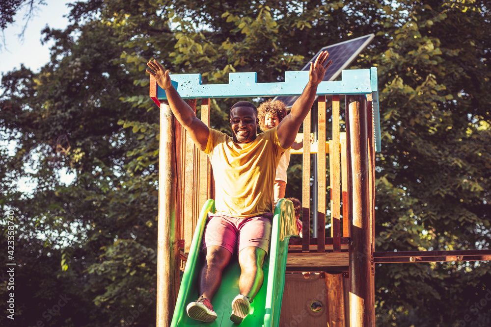 Fototapeta premium African American dad on toboggan with daughter.