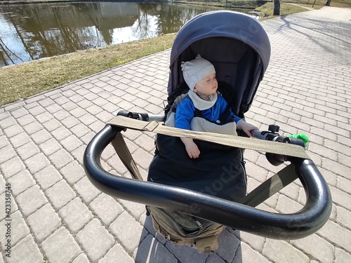 baby sleeping in stroller by the lake