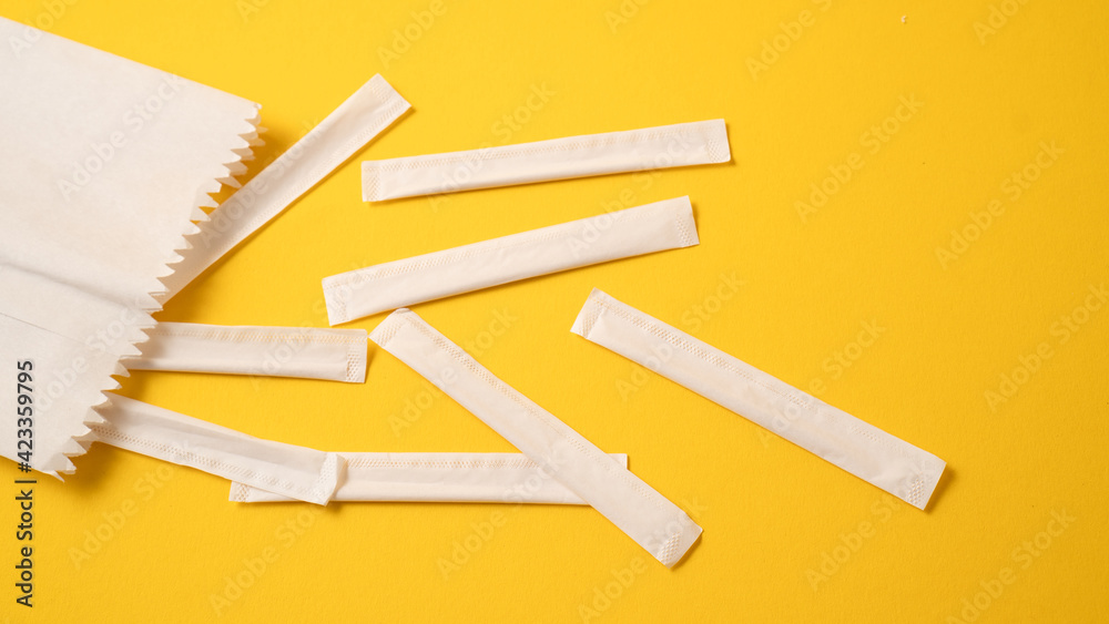 Scattered individual paper wrapped toothpicks. Packed wooden toothpicks