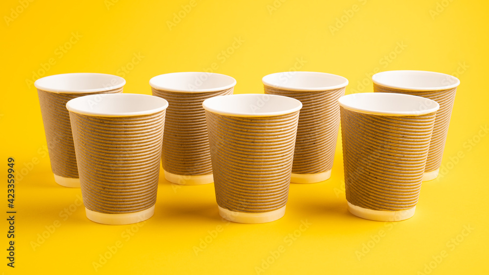 Paper coffee cups. Paper cups for tea on yellow background. Zero waste concept. Gray color coffee paper cups Paper coffee cups. Paper cups for tea on yellow background. Zero waste concept. Gray color coffee paper cups