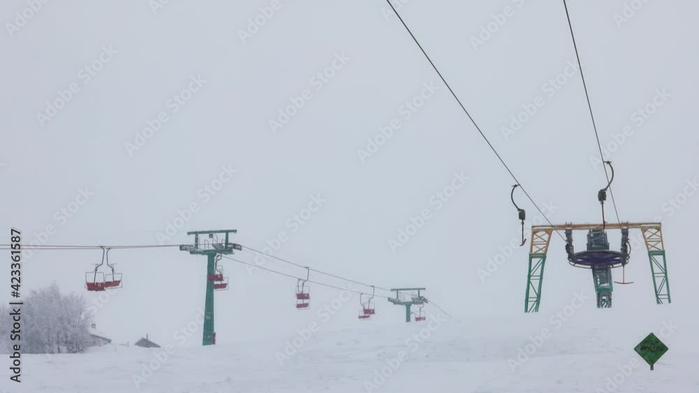 View of the colored lift against the background of a mountain spruce forest and gray sky in the beautiful Carpathians View of the colored lift against the background of a mountain spruce forest and gray sky in the beautiful Carpathians