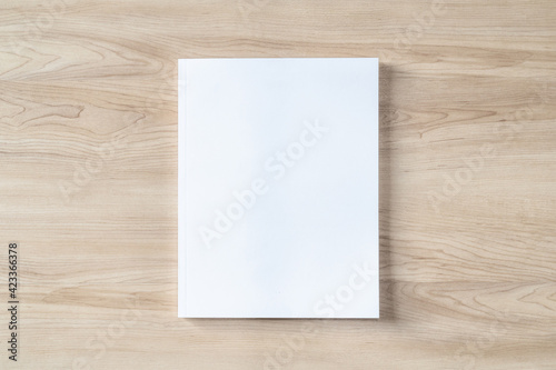 Book cover mockup with blank white front paper page a4 paperback mock up for catalog, magazine, menu, booklet, notebook, portfolio design template on wood table background