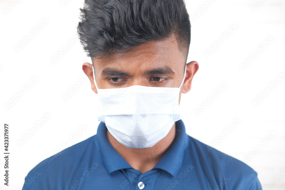 A young man with protective mask against a wall 