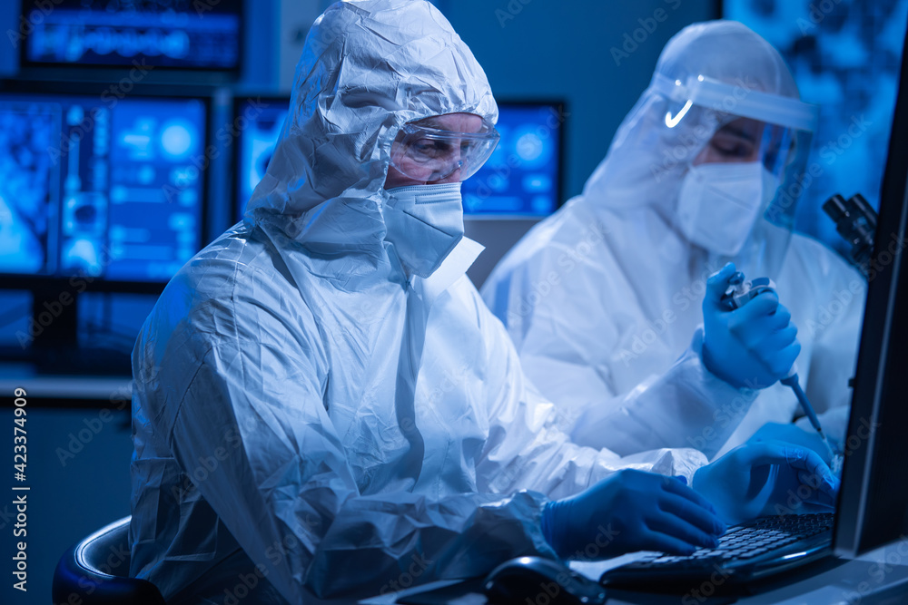 Professional team of scientists is working on a vaccine in a modern scientific research laboratory. Genetic engineer workplace. Future technology and science concept. Professional team of scientists is working on a vaccine in a modern scientific research laboratory. Genetic engineer workplace. Future technology and science concept.