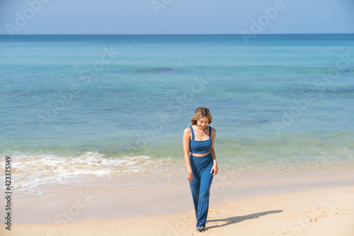 Woman walking on the beach alone. Beach summer holiday vacation.