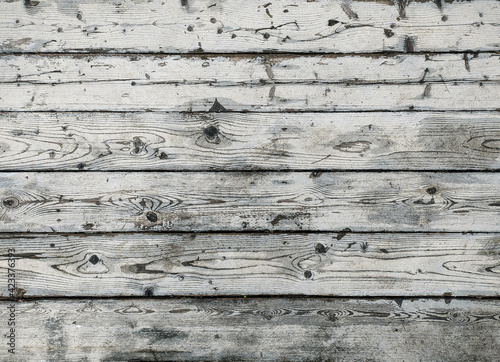 Old white wood plank texture, laid out horizontally, light natural background. The texture of the wood is visible through the cracked and worn layer of white paint.
