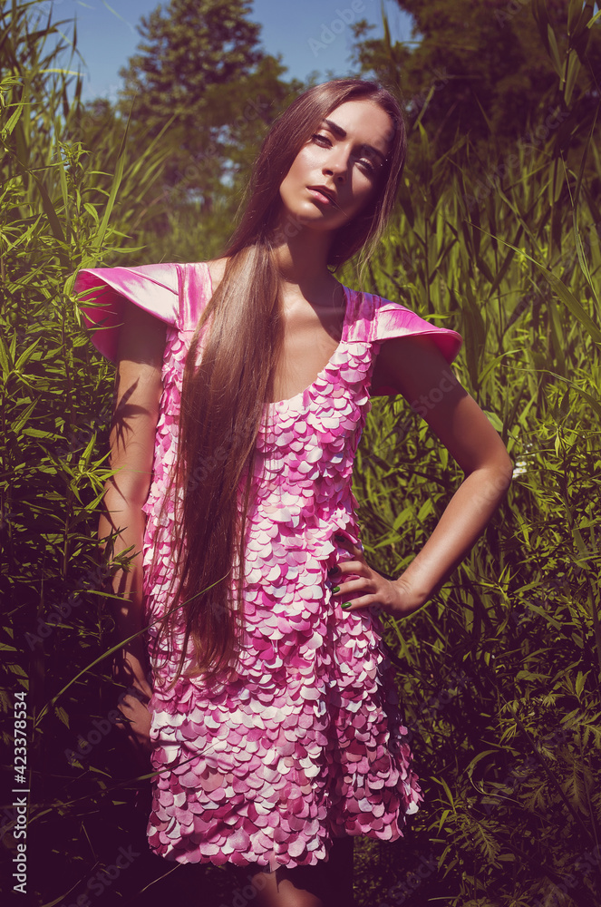 Woman in high grass in pink petal dress Woman in high grass in pink petal dress